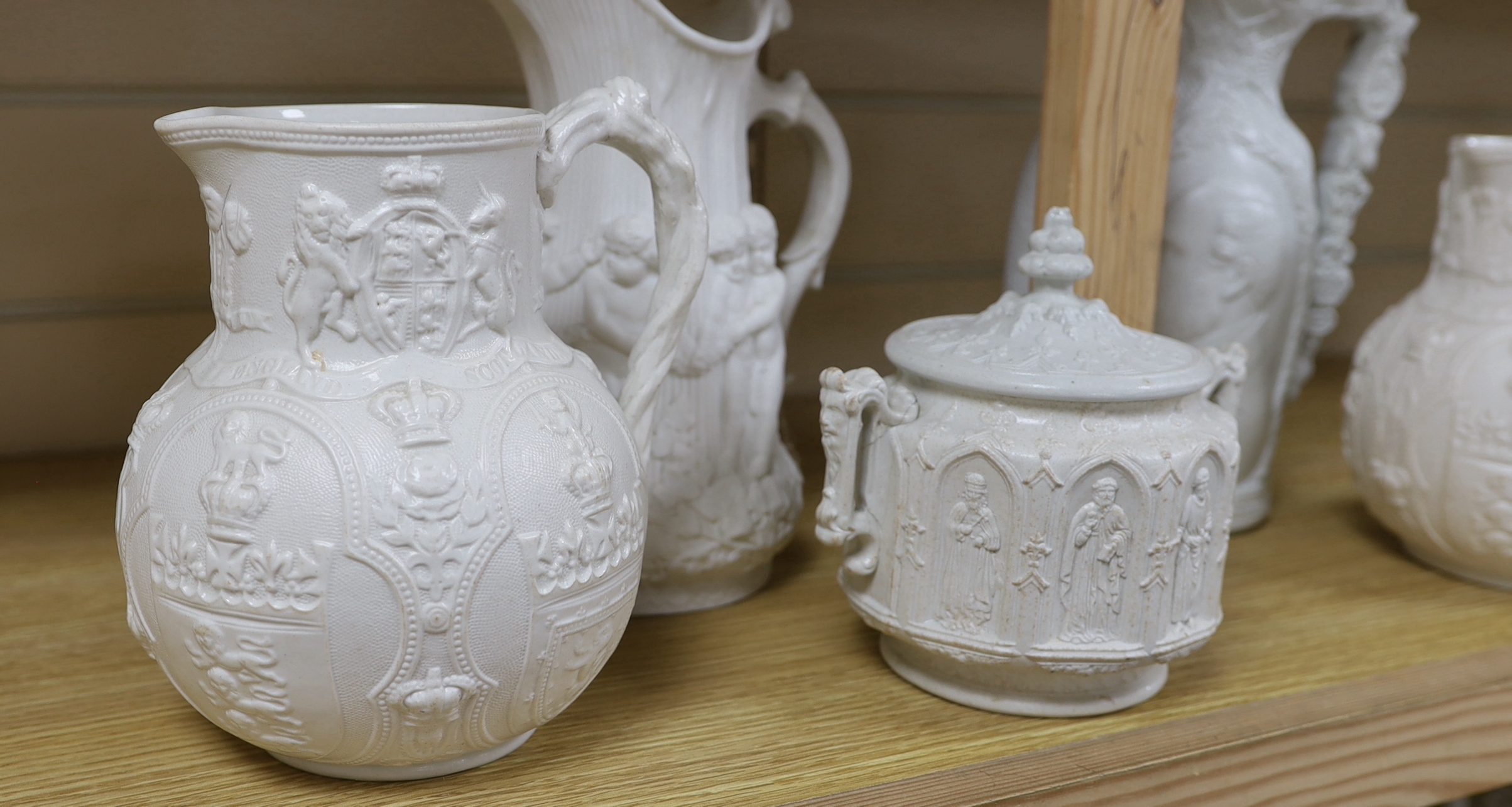 A pair of William Brownfield Parian jugs, moulded with armorials for England, Scotland and Wales, two other Parian ware jugs and a lidded sugar bowl (5), tallest jug 27cm high
